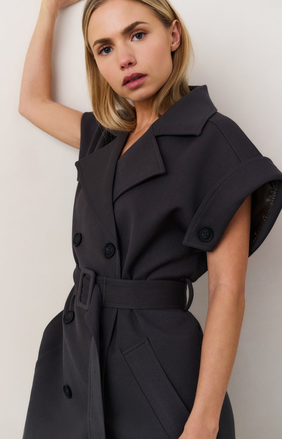 Long sleeveless coat with lapels and waist belt
